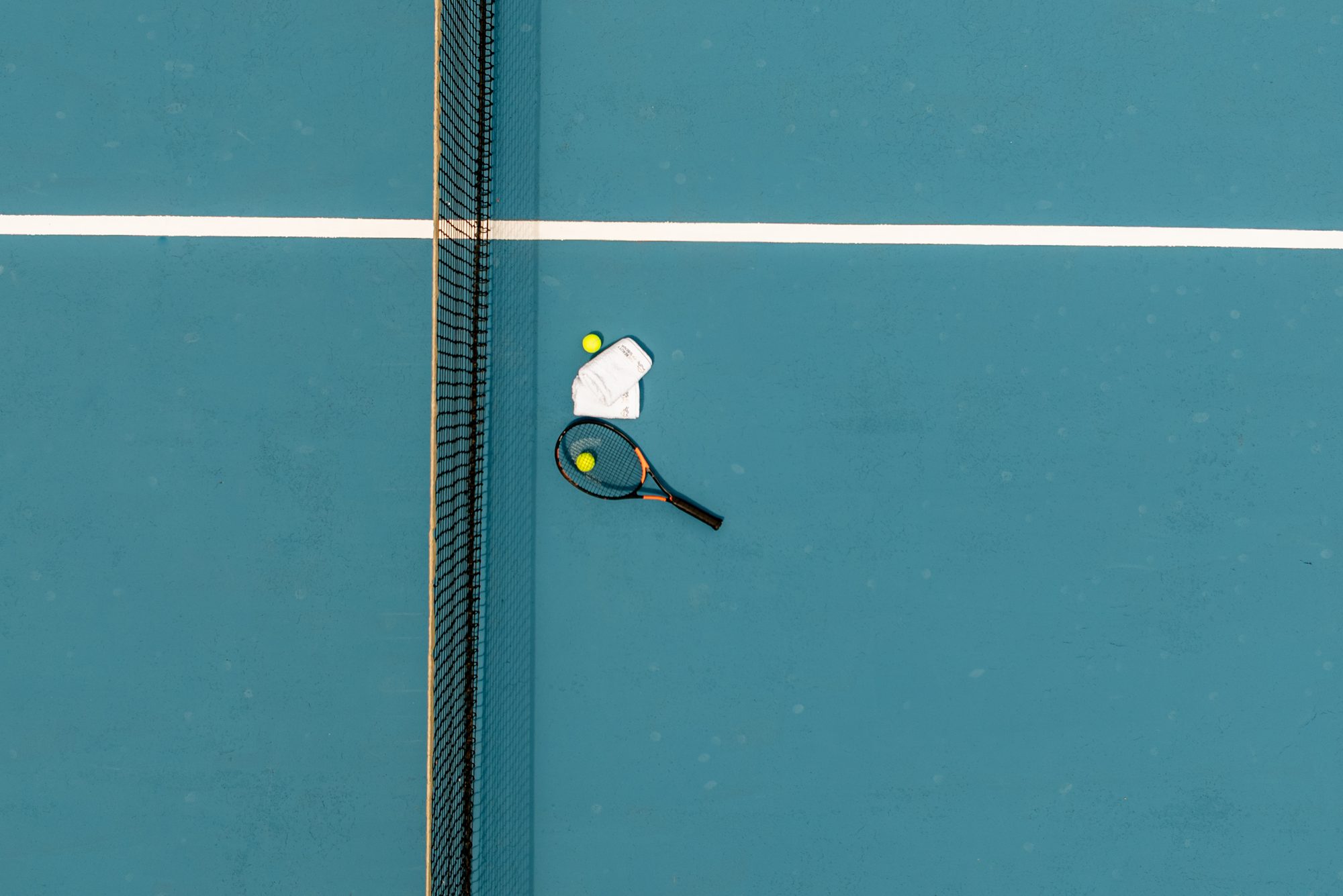 Tennis racket and balls resting on the net of the villa's private tennis court near Sibenik