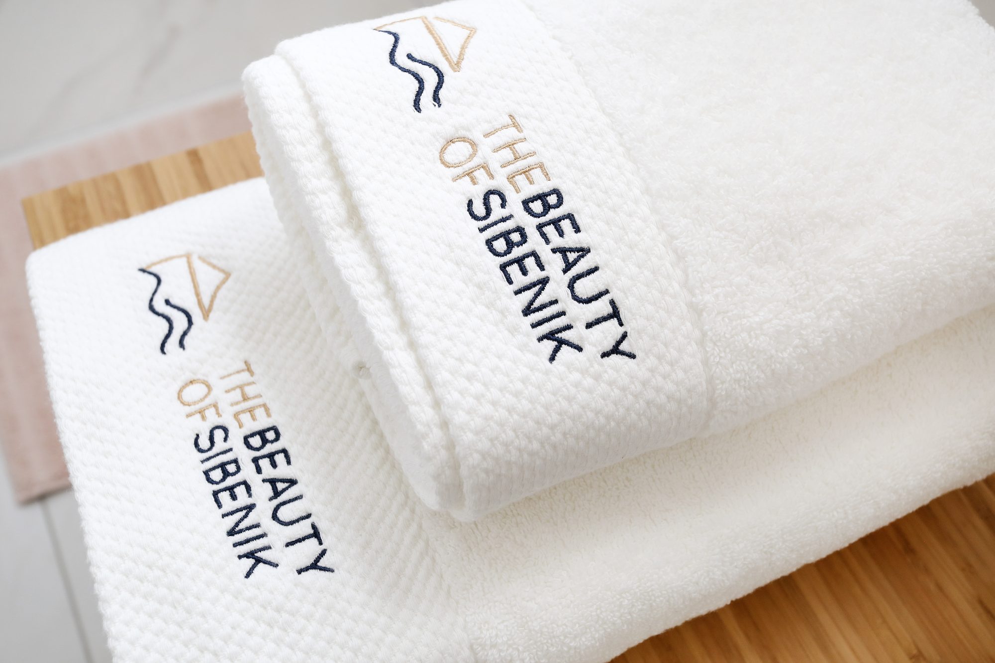 Folded towels embroidered with The Beauty of Sibenik villa logo